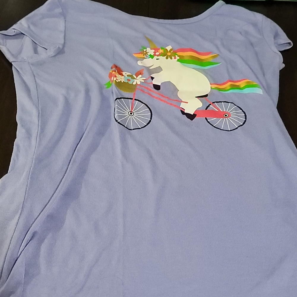A purple shirt a unicorn design